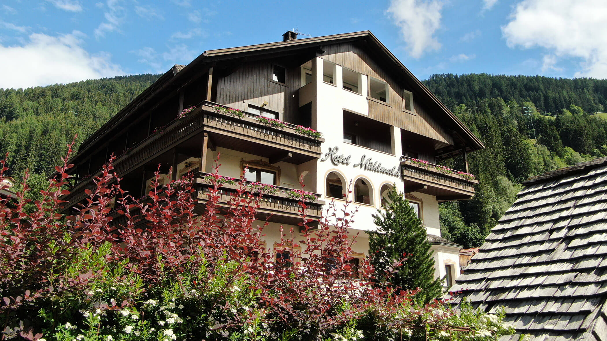 L'Hotel Mühlwald in estate con i fiori del balcone