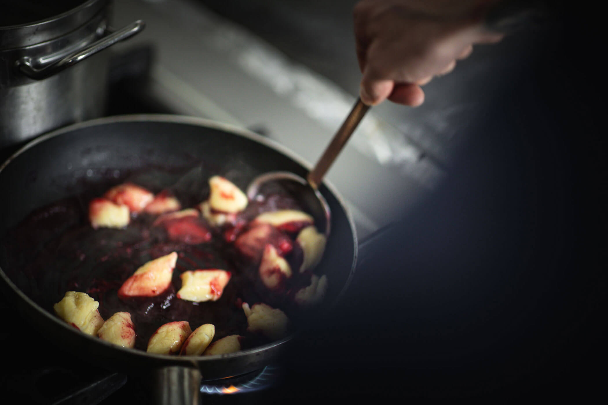 Koch beim Zubereiten von Gnocchi in einer roten Sauce - Hotel Mühlwald
