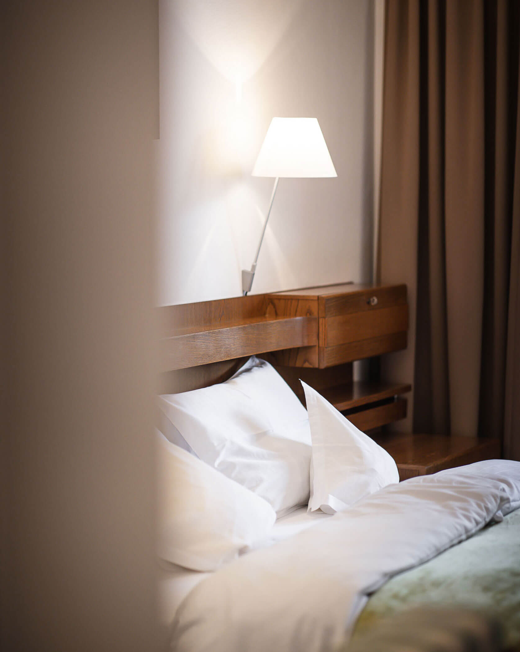 Doppelbett aus dunklem Holz - Hotel Mühlwald